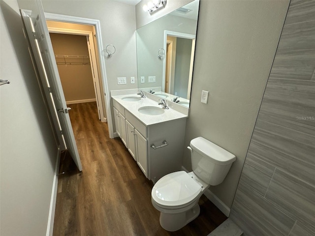 475 Tobias St SE, Palm Bay, FL 32909 - bathroom with toilet, wood finished floors, double vanity, a spacious closet, and baseboards