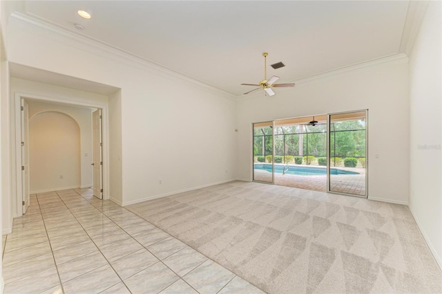 unfurnished room featuring crown molding, arched walkways, ceiling fan, and baseboards