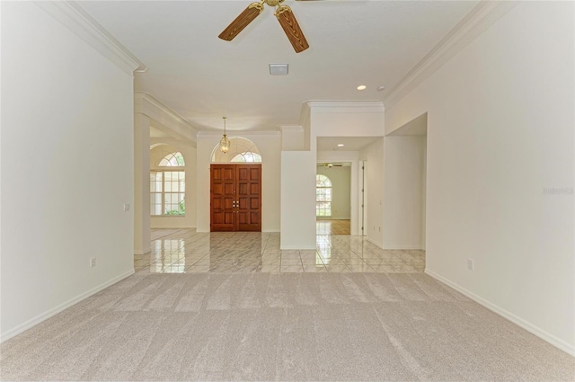 unfurnished room featuring a ceiling fan, visible vents, crown molding, light colored carpet, and baseboards