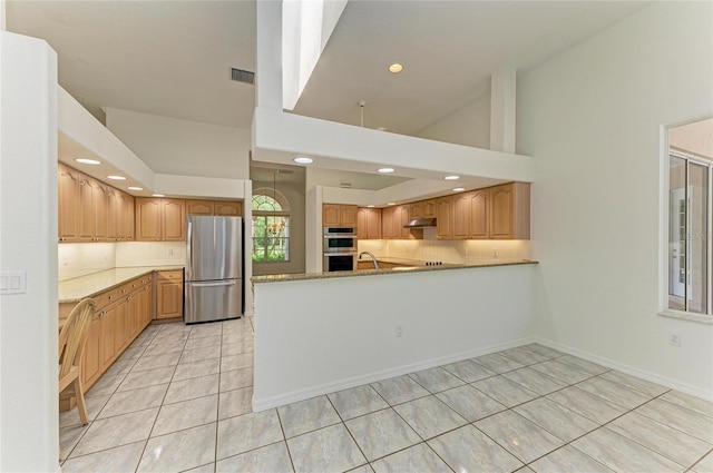 kitchen with a peninsula, appliances with stainless steel finishes, light tile patterned floors, and recessed lighting