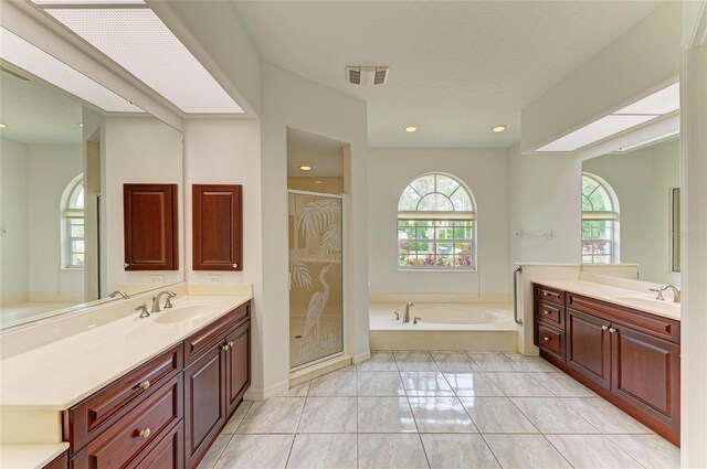 bathroom with visible vents, a sink, a garden tub, and a stall shower