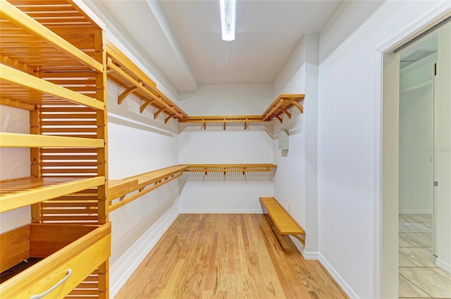 walk in closet with wood finished floors