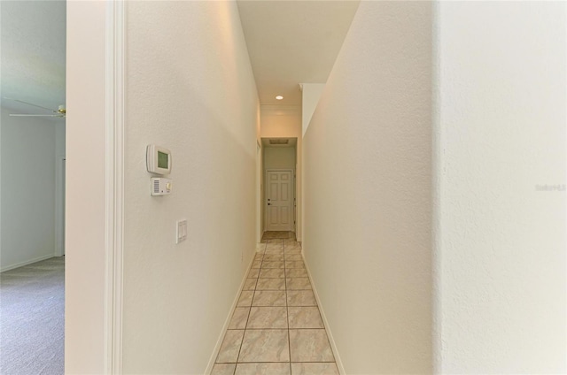 hallway with baseboards, recessed lighting, and light tile patterned flooring