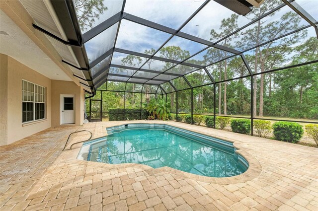 pool featuring glass enclosure and a patio area