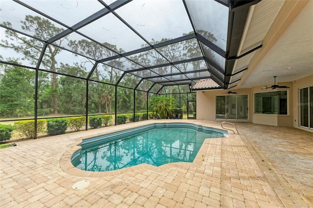 outdoor pool featuring a patio, ceiling fan, and glass enclosure