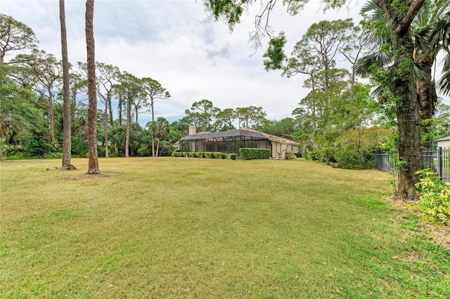 view of yard with fence and a lanai