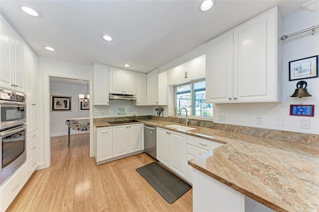 kitchen featuring white cabinets, appliances with stainless steel finishes, under cabinet range hood, and a sink