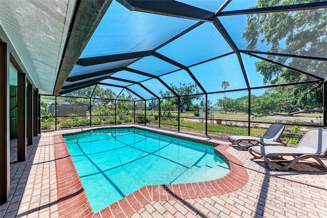 pool with glass enclosure and a patio area