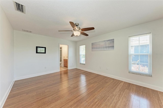unfurnished room with baseboards, visible vents, and light wood finished floors