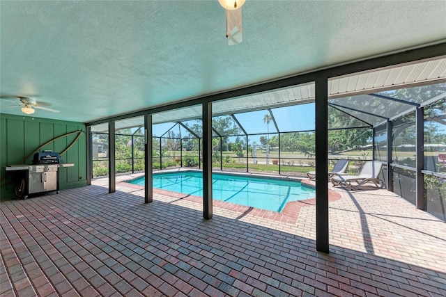 pool featuring a lanai, ceiling fan, a patio, and a grill