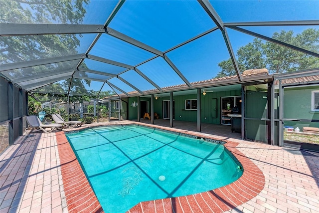 pool featuring glass enclosure and a patio area