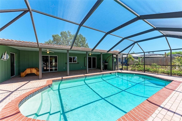 pool with a patio, a ceiling fan, and glass enclosure