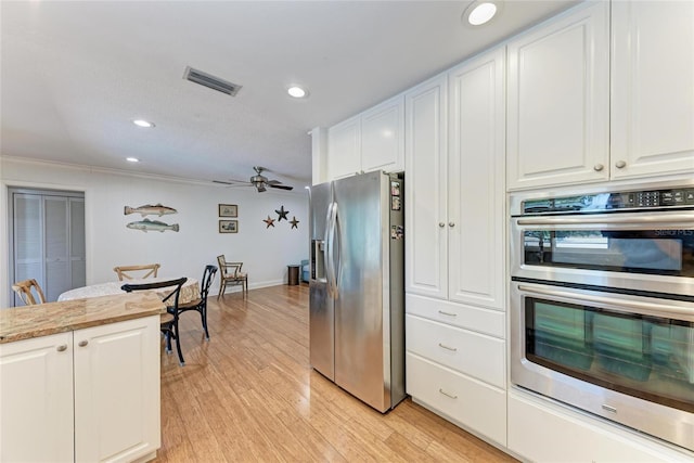 kitchen with recessed lighting, stainless steel appliances, white cabinets, light wood finished floors, and visible vents