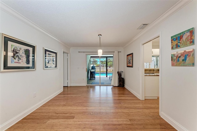 unfurnished dining area featuring ornamental molding, visible vents, and light wood-type flooring