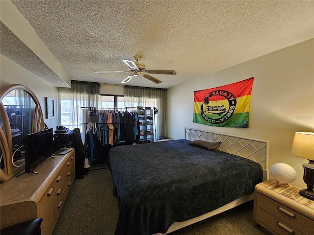 bedroom featuring ceiling fan, dark colored carpet, and a textured ceiling