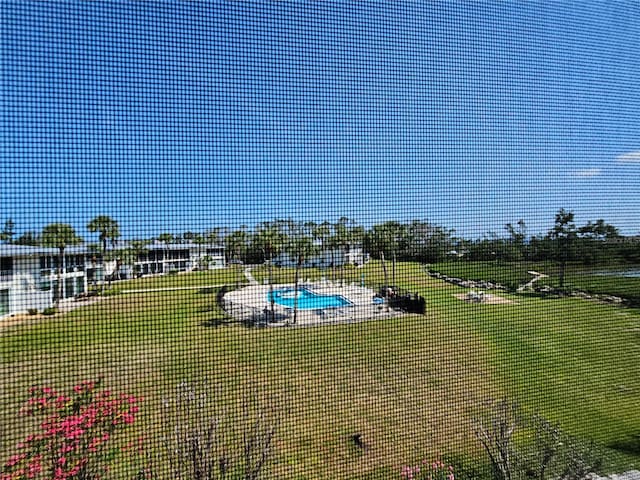 view of swimming pool featuring a yard