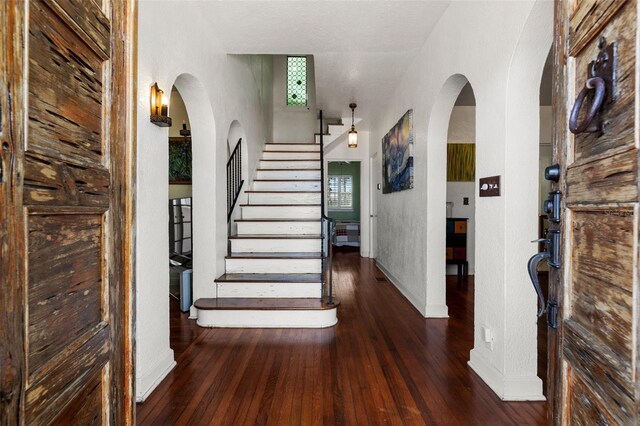 foyer entrance with stairway, plenty of natural light, and wood-type flooring