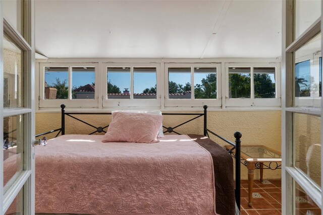 tiled bedroom featuring multiple windows
