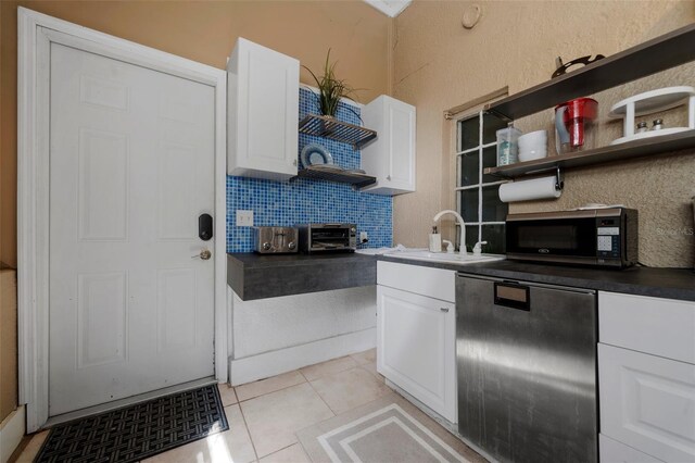 kitchen with open shelves, a sink, stainless steel microwave, and white cabinetry