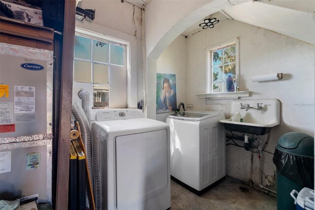 washroom with a sink, arched walkways, laundry area, and independent washer and dryer
