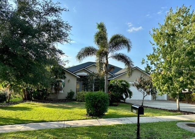 9632 Spring Lake Dr, Clermont, FL 34711 - obstructed view of property with a front yard, stucco siding, driveway, and an attached garage