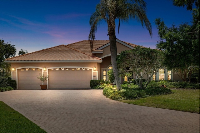 6231 Cypress Bend Ct, University Park, FL 34201 - mediterranean / spanish home with decorative driveway, a garage, stucco siding, a tile roof, and a front yard