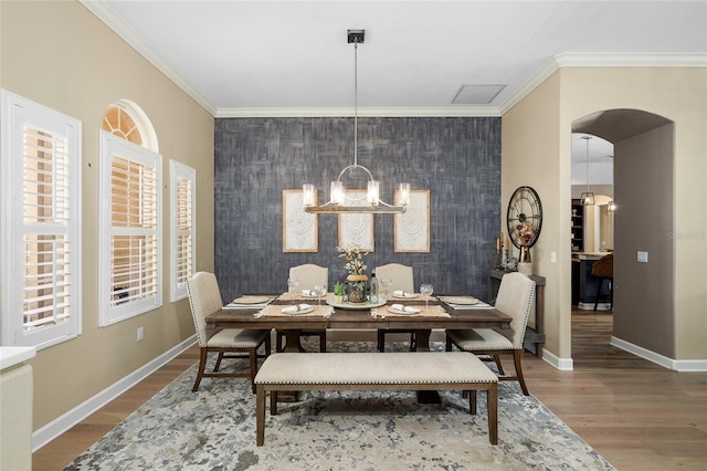 6231 Cypress Bend Ct, University Park, FL 34201 - dining area with an accent wall, a chandelier, wood finished floors, baseboards, and ornamental molding