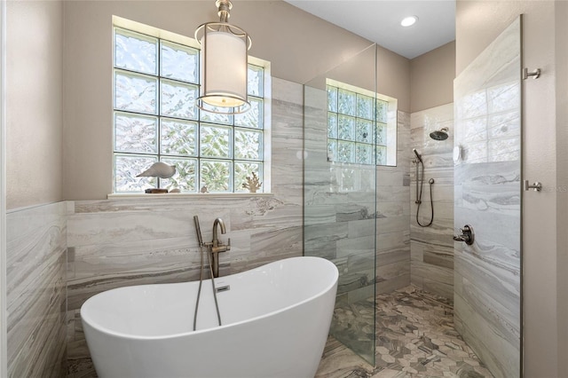 6231 Cypress Bend Ct, University Park, FL 34201 - bathroom with tile walls, a soaking tub, and a walk in shower