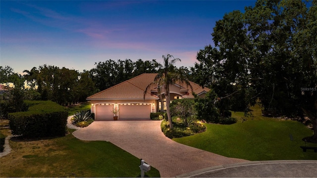 6231 Cypress Bend Ct, University Park, FL 34201 - view of front of house with decorative driveway, an attached garage, a front lawn, stucco siding, and a tile roof