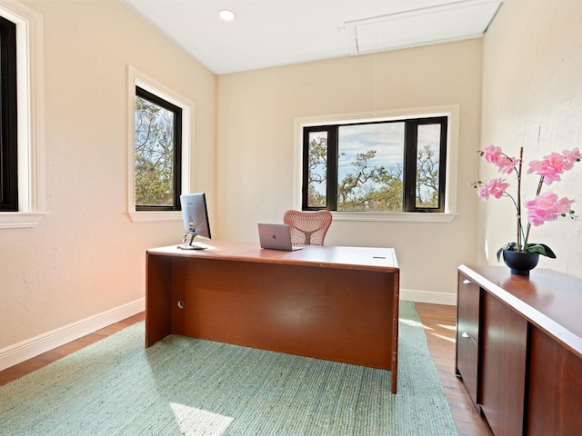 office space with attic access, plenty of natural light, light wood-style flooring, and baseboards