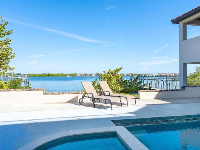 outdoor pool featuring a water view and a patio area