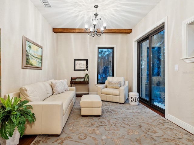 living area with visible vents, wood finished floors, a notable chandelier, and beamed ceiling