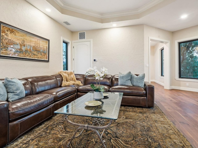 living room featuring recessed lighting, wood finished floors, visible vents, a raised ceiling, and crown molding