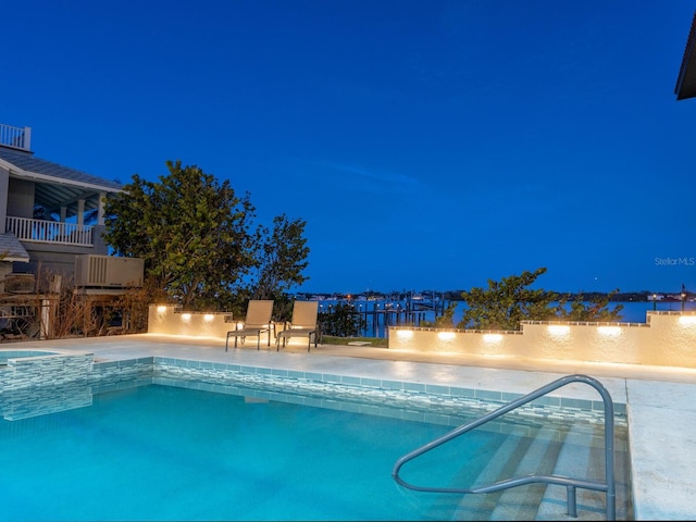 pool at night featuring a community pool