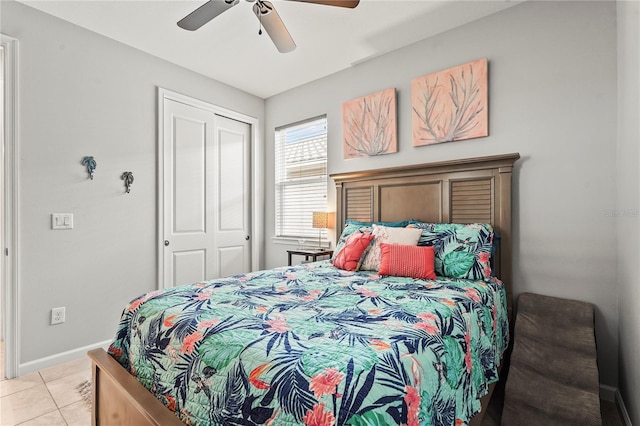 bedroom with light tile patterned floors, baseboards, ceiling fan, and a closet
