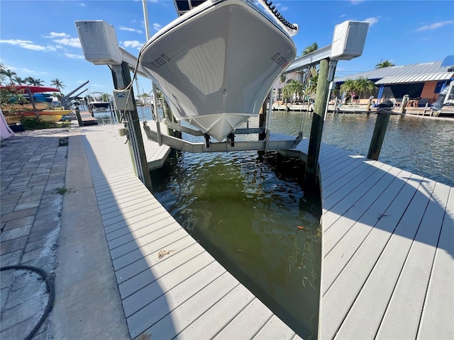 view of dock featuring boat lift and a water view