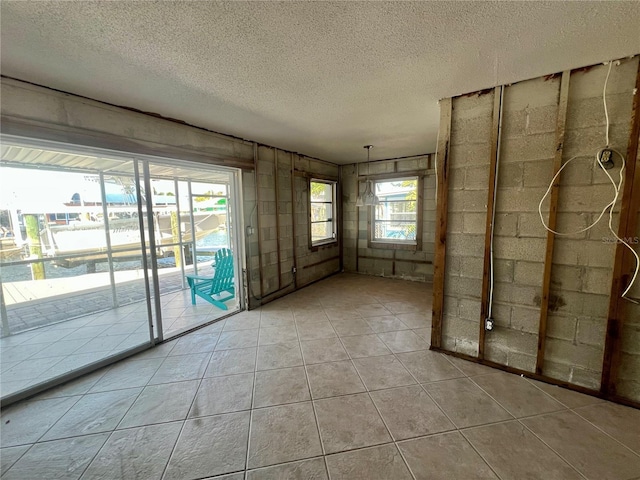 empty room with light tile patterned floors and a textured ceiling