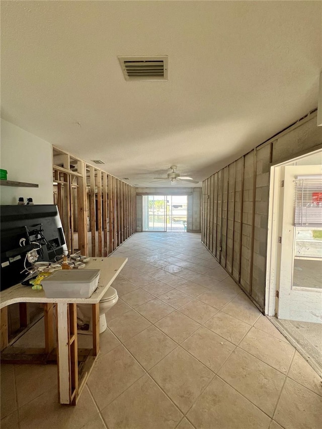 corridor featuring visible vents, a textured ceiling, and tile patterned flooring