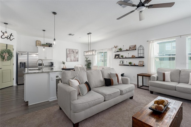 10464 Ladybug Cv, Parrish, FL 34219 - living area with a ceiling fan, dark wood-type flooring, a chandelier, dark carpet, and baseboards