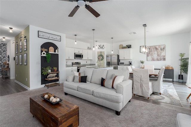 10464 Ladybug Cv, Parrish, FL 34219 - living area with a ceiling fan, wood finished floors, and baseboards