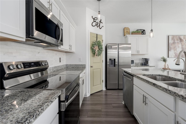 10464 Ladybug Cv, Parrish, FL 34219 - kitchen featuring stainless steel appliances, a sink, white cabinets, dark wood-style flooring, and backsplash