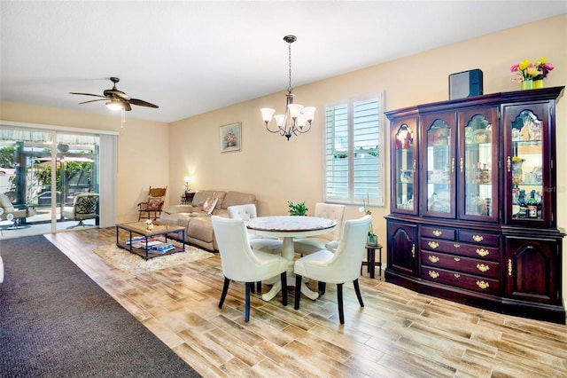 dining room featuring wood finished floors and ceiling fan with notable chandelier