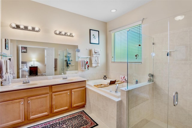full bathroom with a bath, a sink, a stall shower, and ensuite bathroom