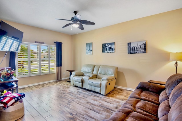 living area featuring wood finished floors, ceiling fan, and baseboards