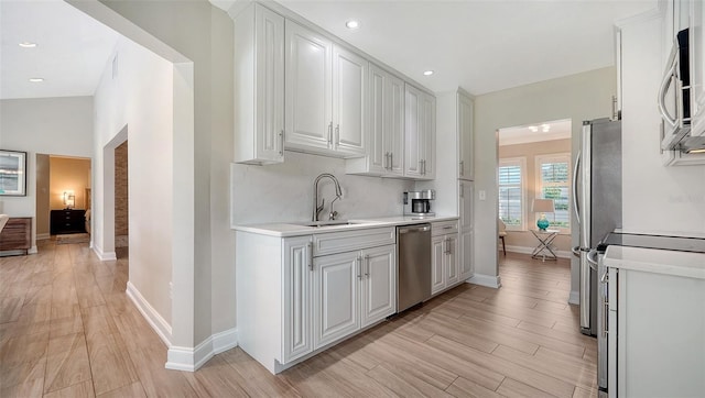4861 Waterbridge Down, Sarasota, FL 34235 - kitchen with appliances with stainless steel finishes, light countertops, light wood-style floors, white cabinets, and recessed lighting