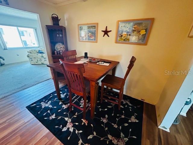 dining room with crown molding and wood finished floors