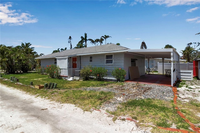 7030 Lois Ave, Longboat Key, FL 34228 - ranch-style house with driveway, an attached carport, and fence