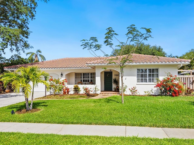 single story home featuring a garage, a tile roof, stucco siding, and a front yard
