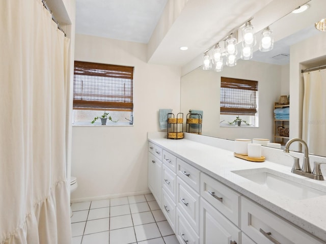 bathroom featuring toilet, vanity, tile patterned floors, and baseboards