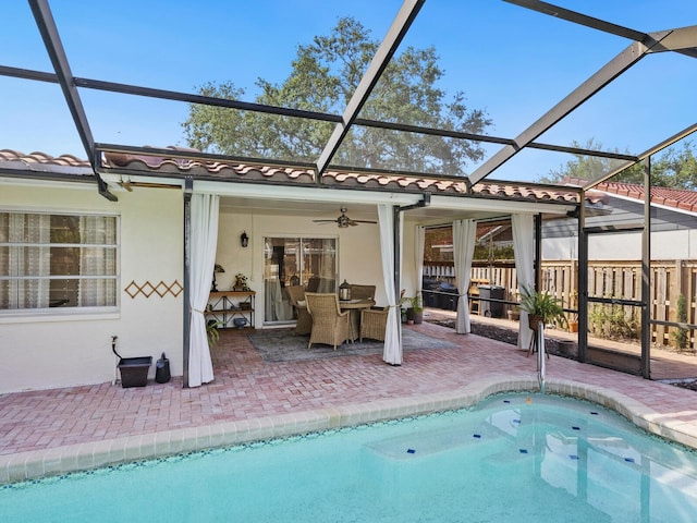 outdoor pool with a lanai, ceiling fan, and a patio area